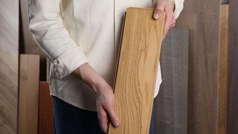 man holding wood flooring sample